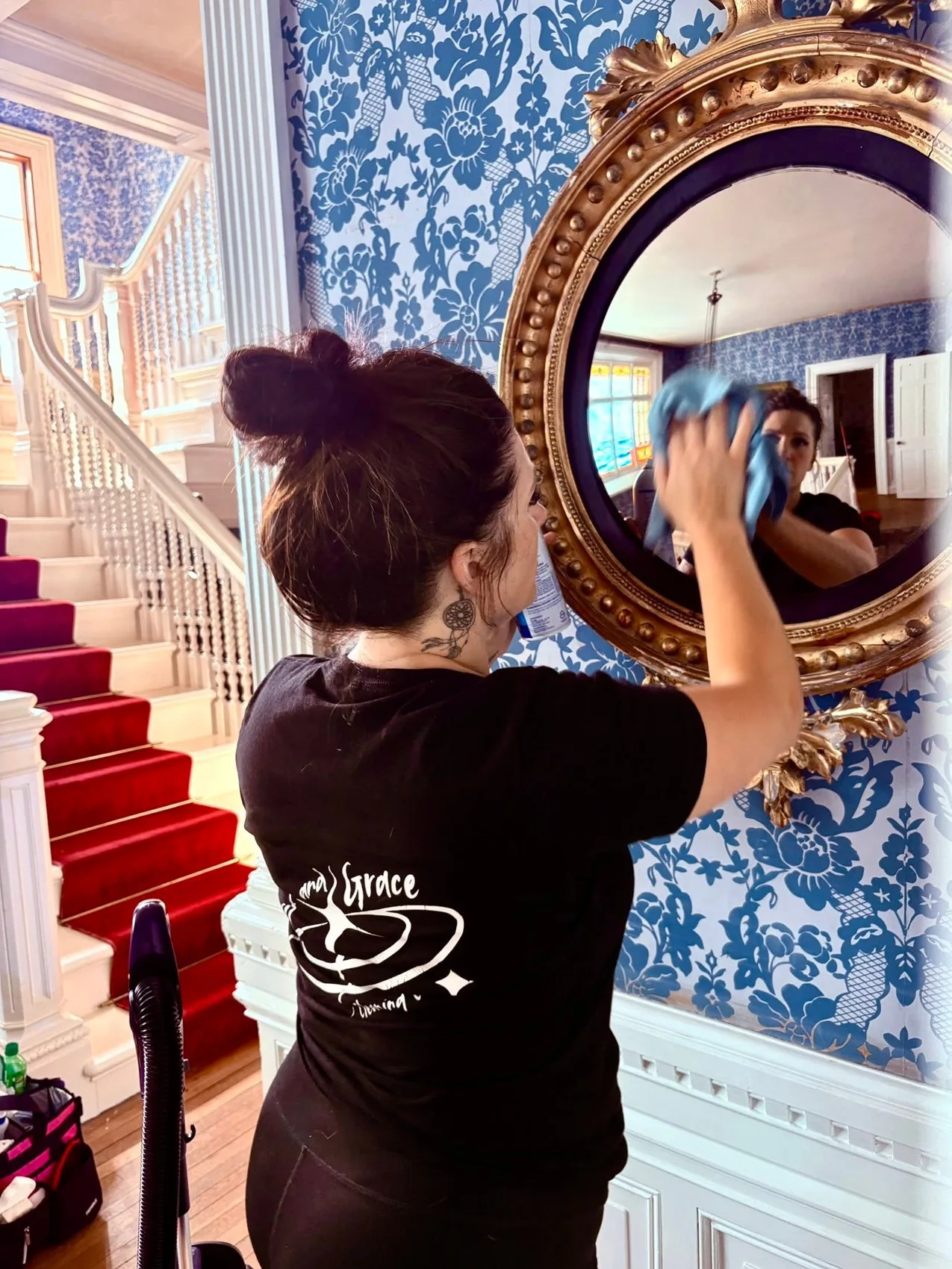Grit and Grace team member carefully polishing a mirror inside a beautiful home
