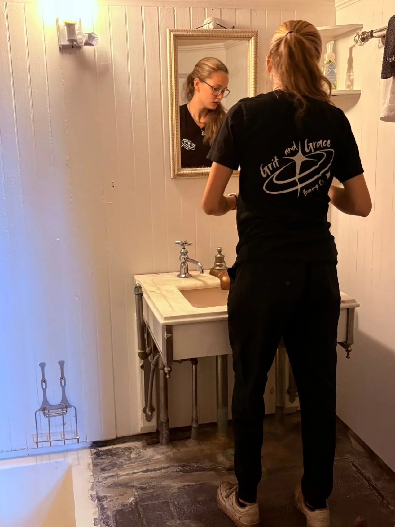 Grit and Grace cleaner working with care in a home's bathroom